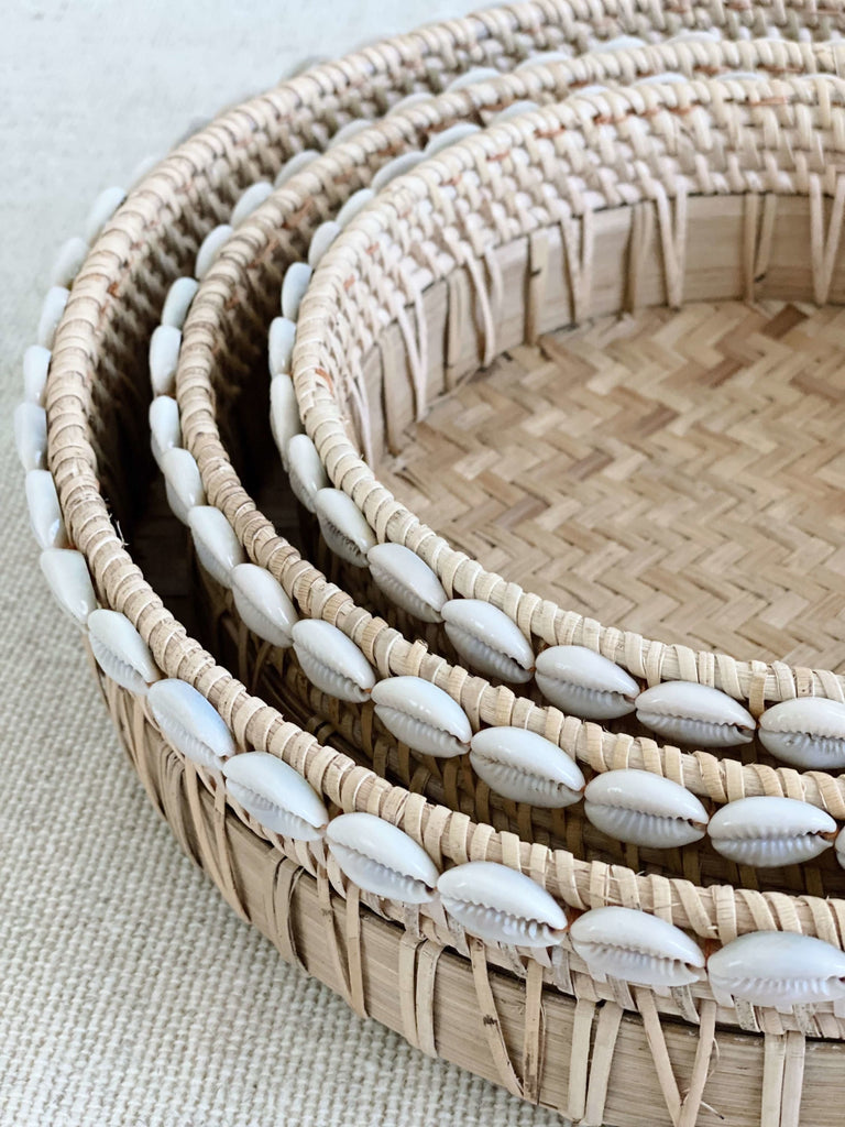 detailed close-up of handwoven bamboo nesting tray set with cowrie shell detail
