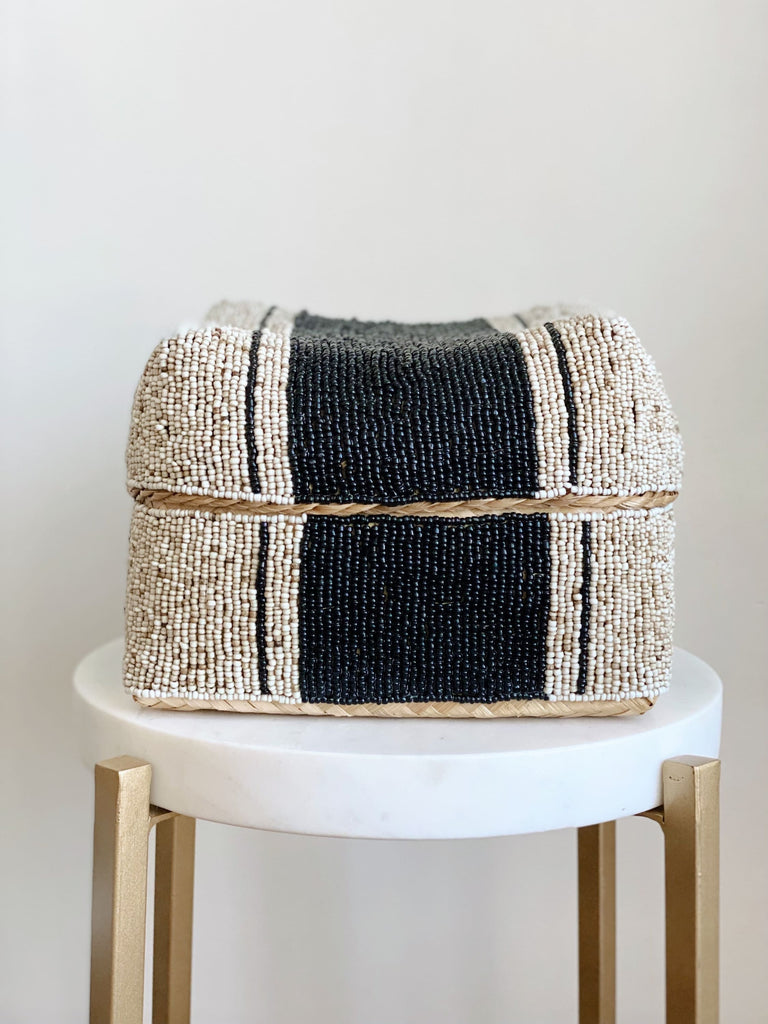 medium hand-beaded black and beige bamboo basket on white marble stool