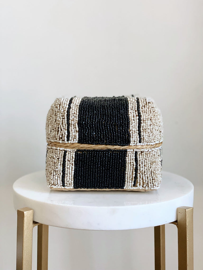 small hand-beaded black and cream bamboo basket on white marble stool