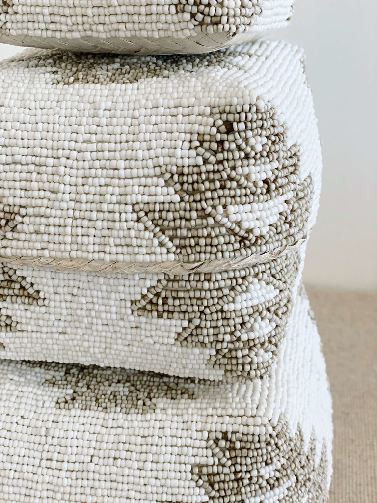 detailed shot of tribal design on white and tan beaded bamboo basket set