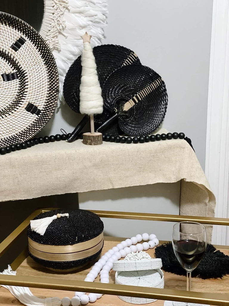 decorative assortment of boho decor with round hand-beaded black bamboo basket wall basket palm leaf fans