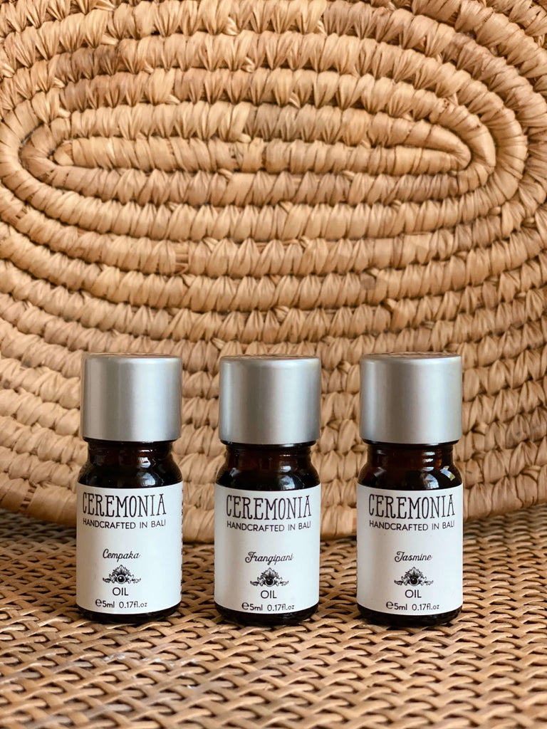 set of three cempaka frangipani jasmine essential oils with woven wicker background