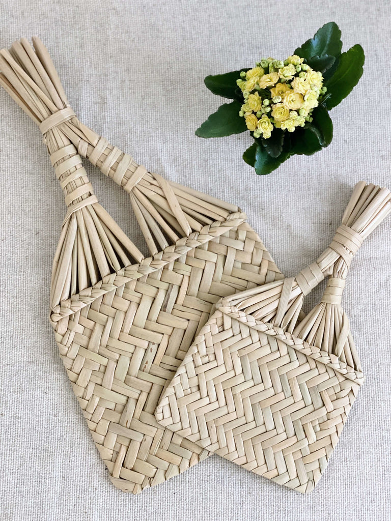 handmade small and medium natural fiber fans on canvas next to yellow florals