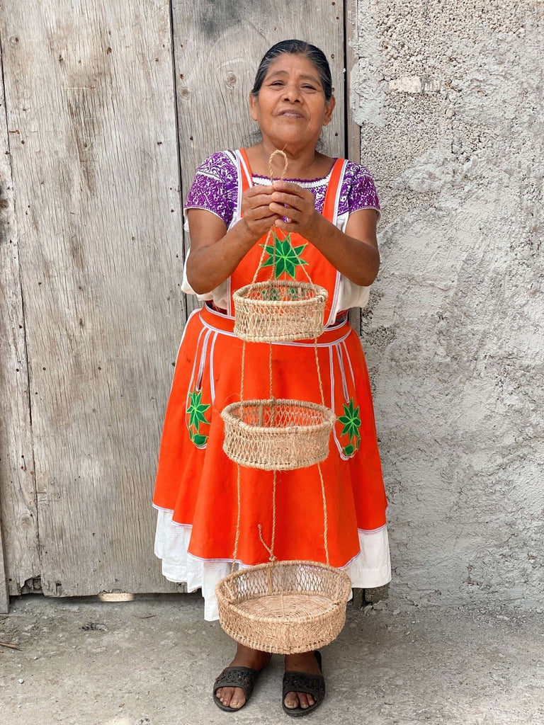 indonesian artisan woman in traditional clothing poses with handwoven trio jonote basket
