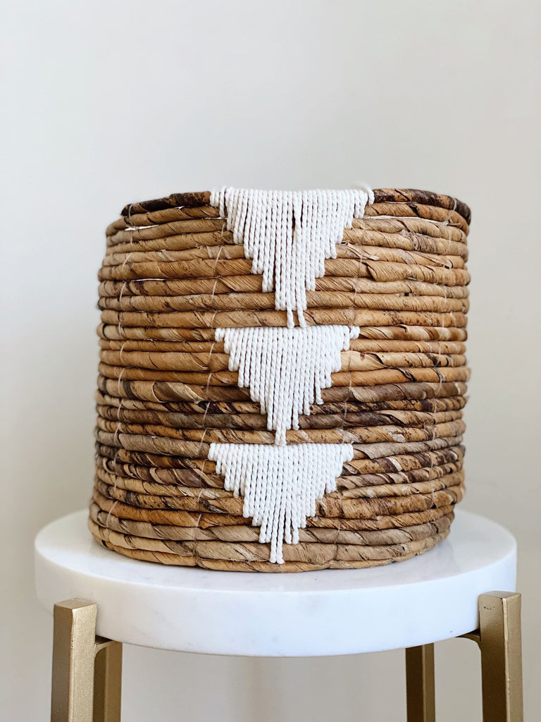 medium brown handwoven banana leaf plant basket pot with white triangle design on white stool
