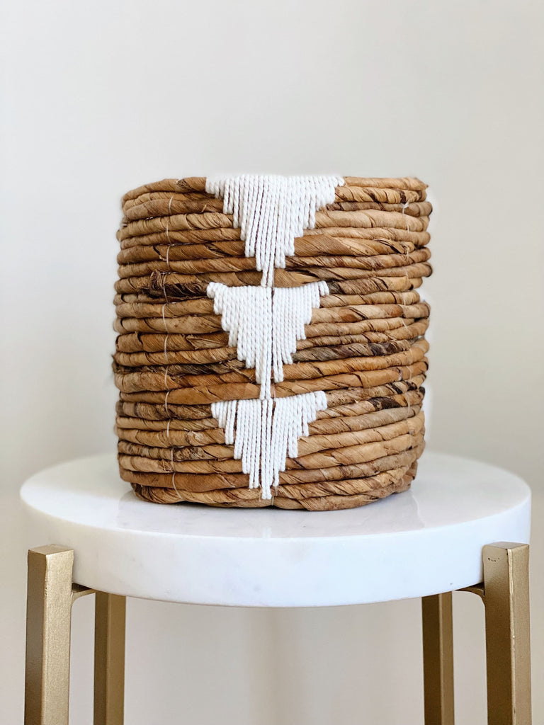 mini brown handwoven banana leaf plant basket pot with white triangle design on white stool