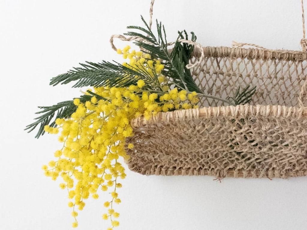 handwoven jonote huacal wall basket holding dried florals