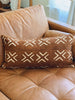 brown vintage african mudcloth throw pillow on leather brown cognac sofa