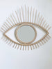 product photo of modern boho open eye rattan mirror on white wall
