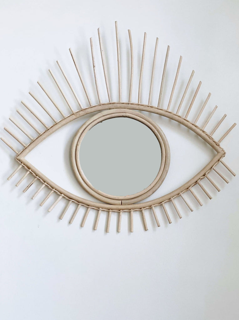 product photo of modern boho open eye rattan mirror on white wall