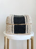 medium hand-beaded black and beige bamboo basket on white marble stool
