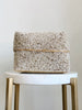 medium hand-beaded tan bamboo basket on white marble stool