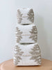 stack of three beaded bamboo baskets with tribal print on minimalist wooden stool