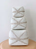 stack of three beaded bamboo baskets with minimalist white and tan pattern