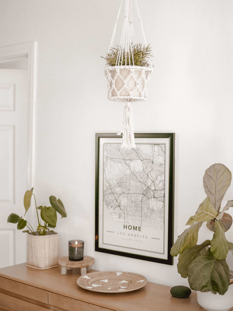 beaded macrame plant hanger above a wooden dresser with other bohemian decor in modern boho bedroom