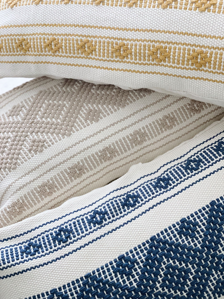 close up details of embroidery on colorful handmade waistloom throw pillows 