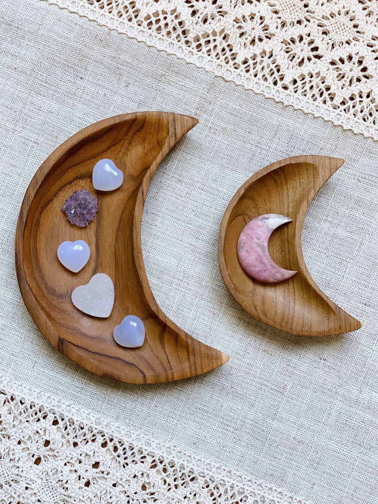 set of 2 hand-carved crescent moon teak dish holding heart and moon shaped crystals