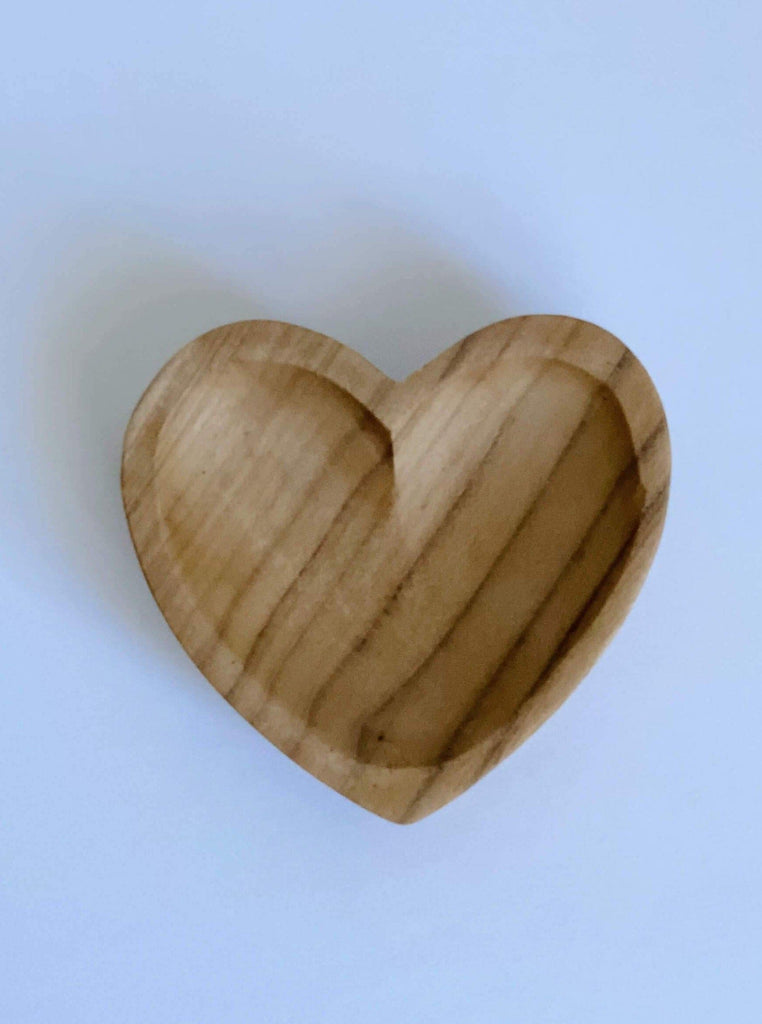 close-up product photo of mini hand-carved heart teak dish on a white surface
