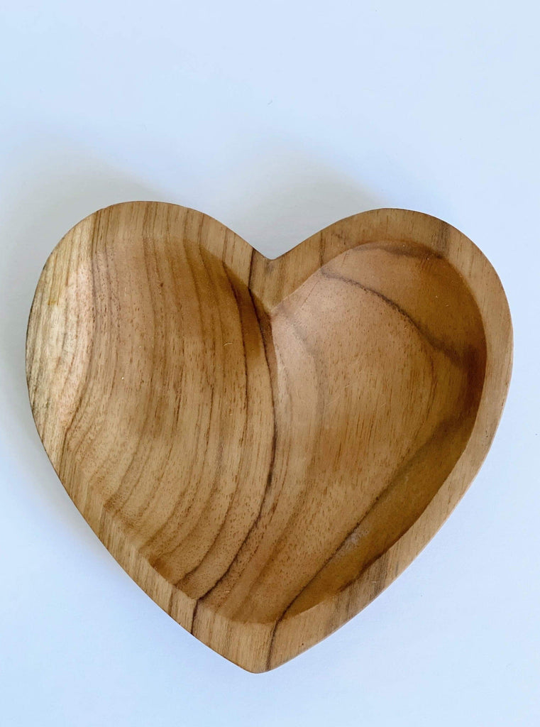 close-up product photo of small hand-carved heart teak dish on a white surface