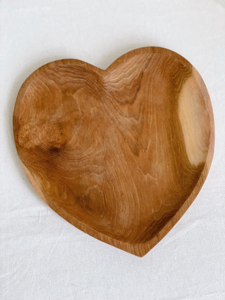 close-up product photo of large hand-carved heart teak dish on a white surface
