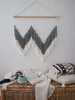 bohemian wall hanging black and white wall hanging over a rattan dresser with a cozy boho setup