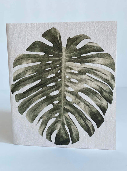 white stationary card with a large monstera leaf