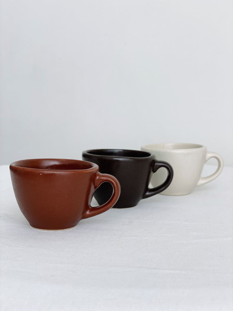 red, dark brown, and white high fire clay stoneware espresso mugs with a white background