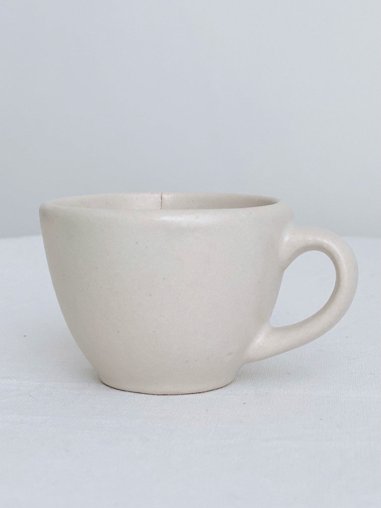 handmade ivory high fire clay stoneware espresso mug with white background