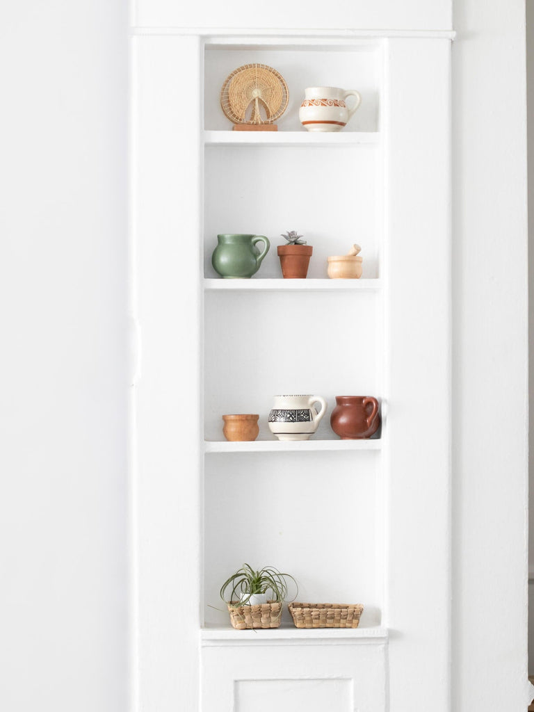 minimalist white pantry shelf with various handmade high fire clay ceramic mugs