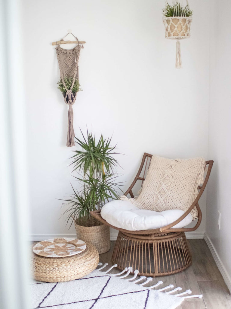 modern bohemian cozy reading nook with hanging macrame plant hangers and rattan decor
