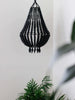 beautiful small black wooden bead bohemian chandelier hanging over plants