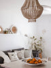 natural wooden bead chandelier hanging over a fruit basket in a beautiful modern bohemian living room
