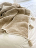 bohemian handwoven jute and linen cream cozy throw blanket with tassels on white bedding