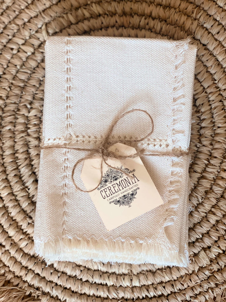 elegant handwoven white linen napkins on raffia placemat