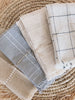 set of four different stunning detailed handwoven natural linen napkins folded neatly on bohemian fringe coaster