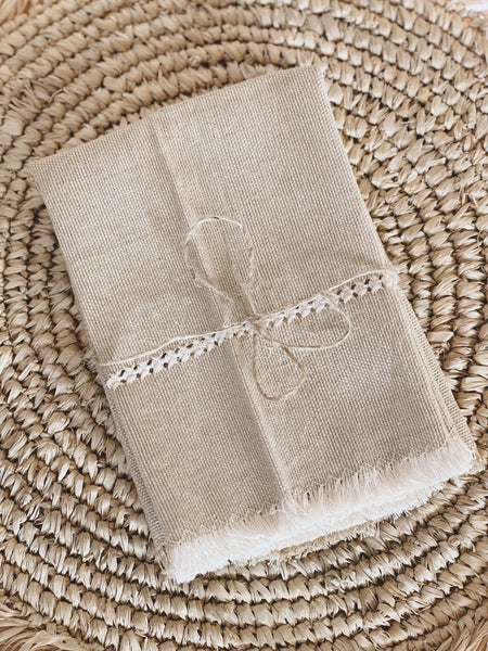 natural tan handwoven square linen napkin set with beautiful detail on raffia fringe coaster