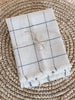bohemian white and navy checkered handwoven square linen napkin set with beautiful detail on raffia fringe coaster