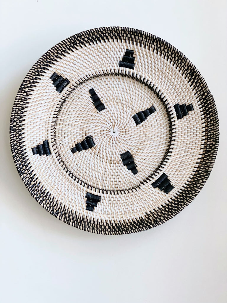 black and white bohemian handwoven rattan wall basket hanging on white wall
