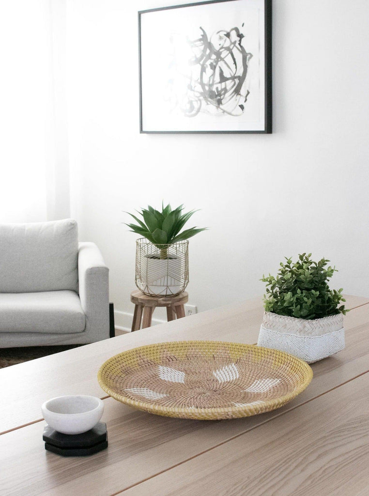 natural yellow handwoven rattan wall basket as table centerpiece in a light filled modern bohemian dining room 