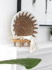 stunning bohemian home decor on mantel with handwoven wall basket and white conus shell tassel