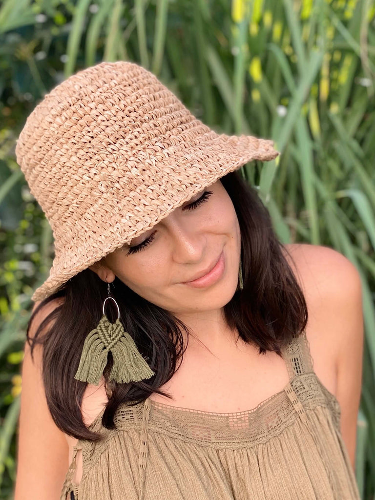 stunning woman wearing hyacinth bucket hat while laying calmly on grass