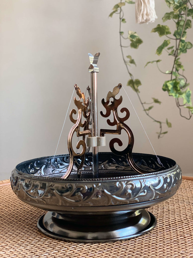 product photo of silver incense coil holder with intricate design