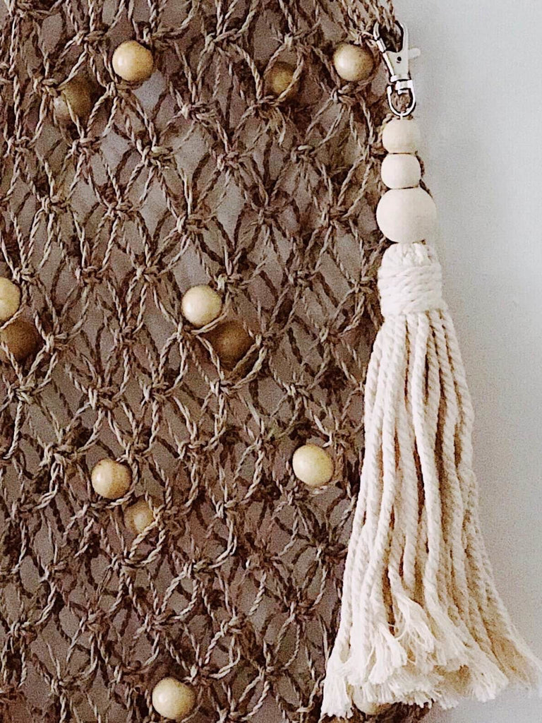 jute bag fishetnet totebag with hanging tassel charm accessory detail close up