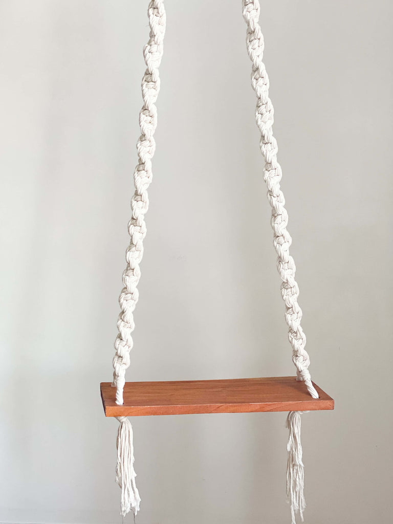 cute bohemian macrame wooden swing hanging from ceiling with white background