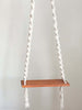 cute bohemian macrame wooden swing hanging from ceiling with white background