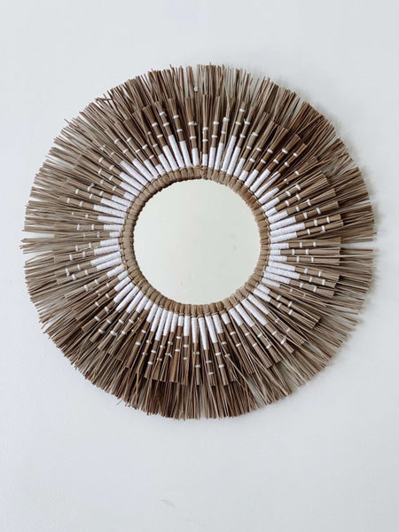 bohemian brown and white papyrus mirror motif hanging on white wall
