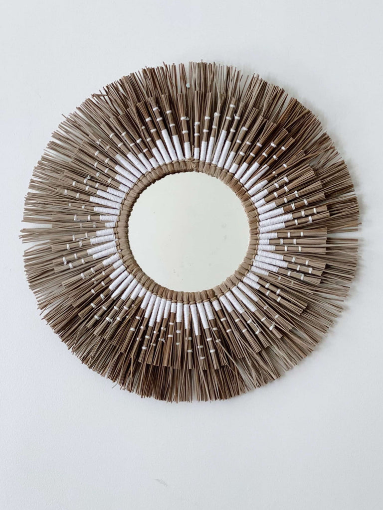 bohemian brown and white papyrus mirror motif hanging on white wall
