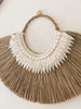 closeup detail shot of earthy bohemian mendong grass beaded wall hanging on white wall