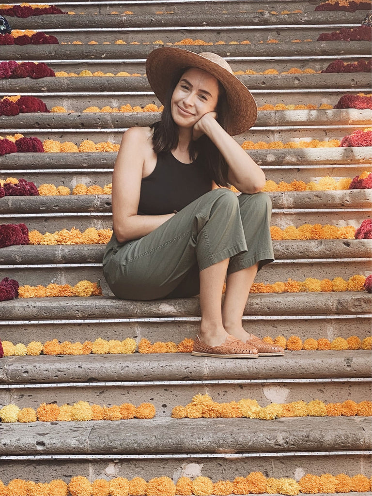 girl wearing mexican artisan handwoven sombrero sun hat on floral staircase