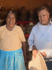happy mexican artisan couple in workshop with various palm leaf sombreros